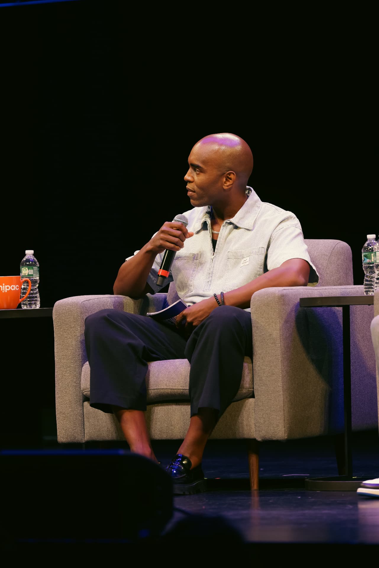 Moderator seated on stage during a ViewerCon panel