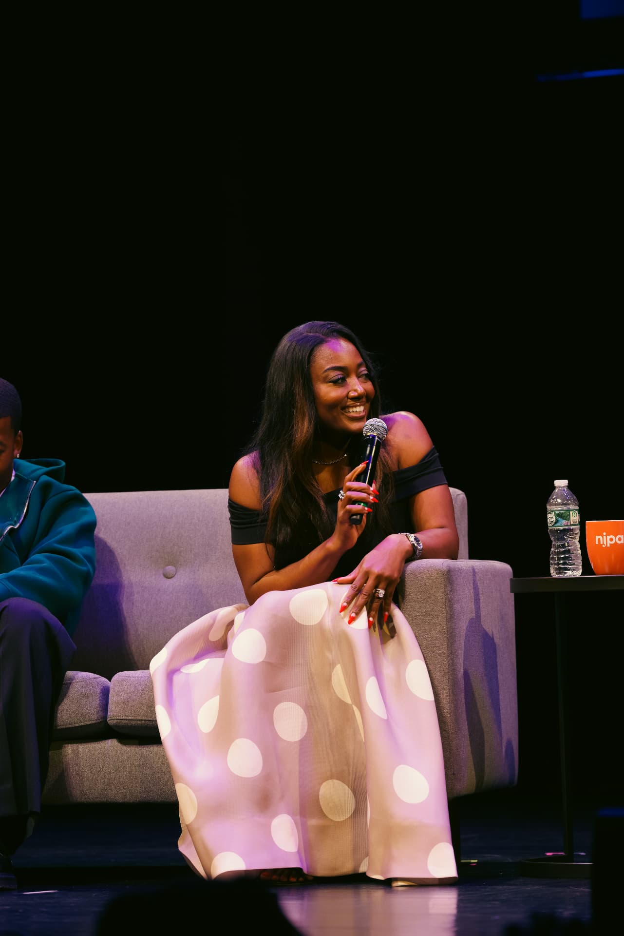 Panelist smiling while answering a question on stage